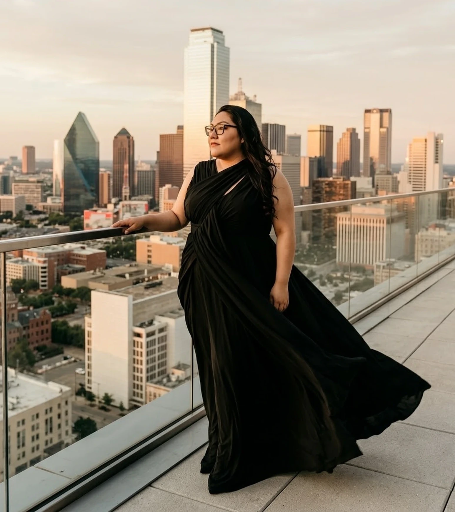 Liz on a rooftop overlooking the Dallas skyline at golden hour